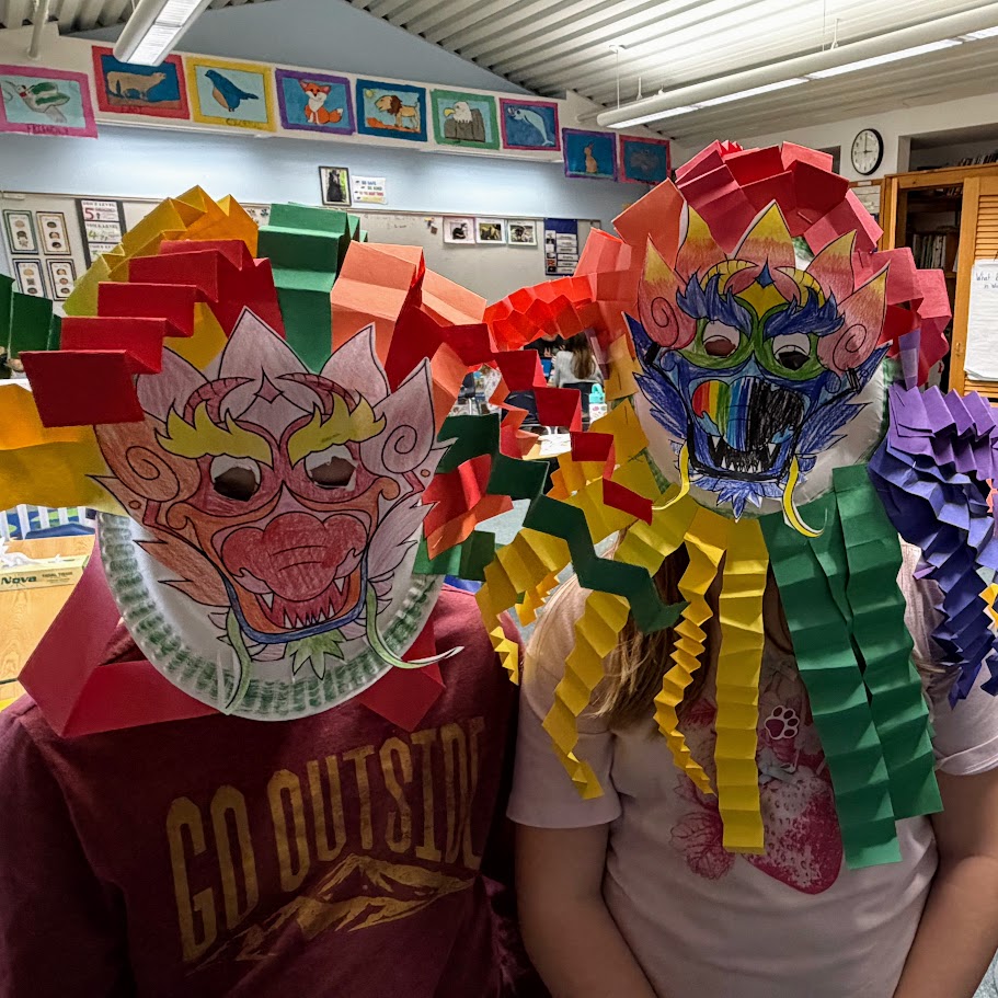 Students wearing dragons masks based on a lunar new year fable. 